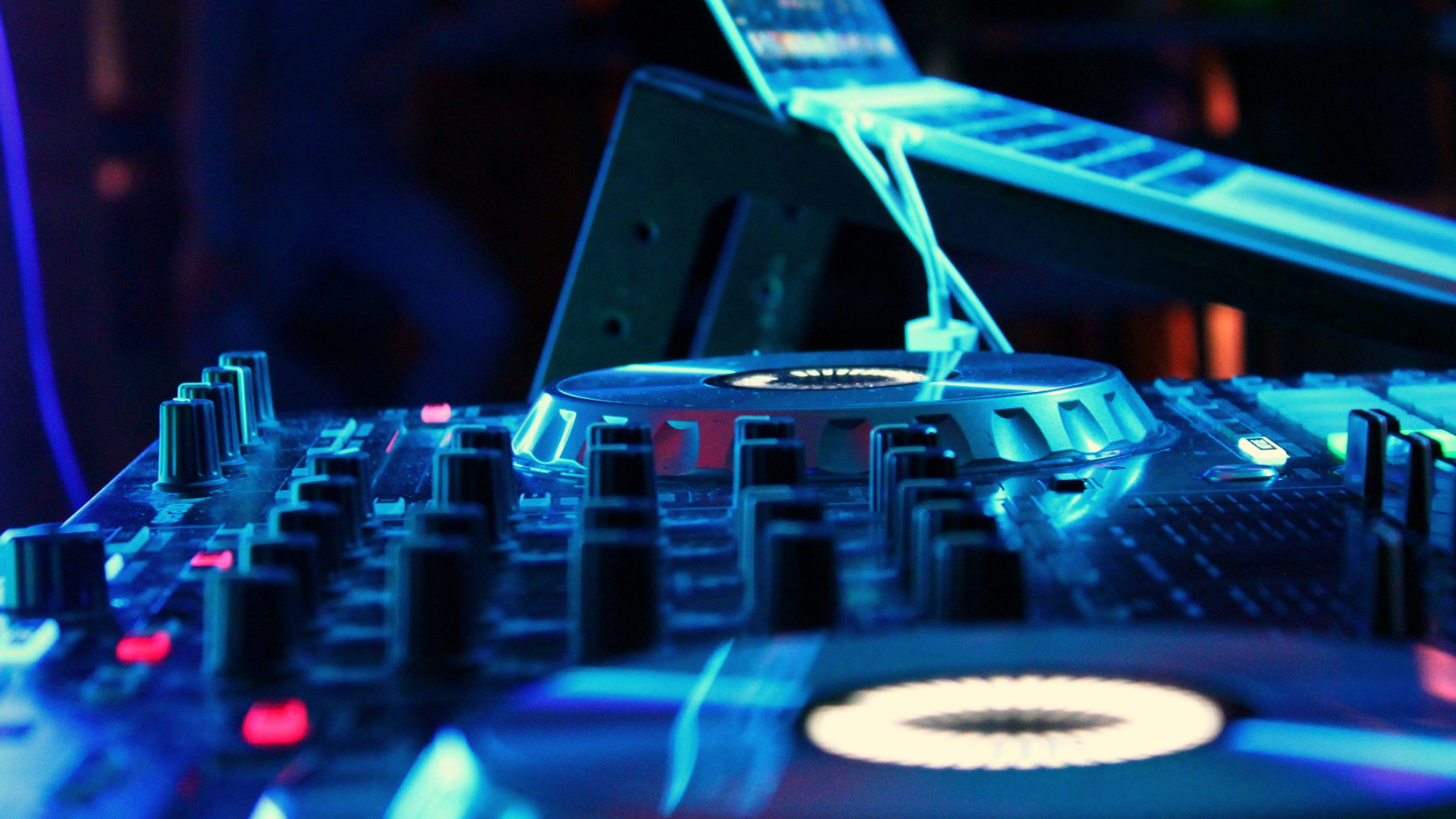 Professional DJ controller lit in blue at an event